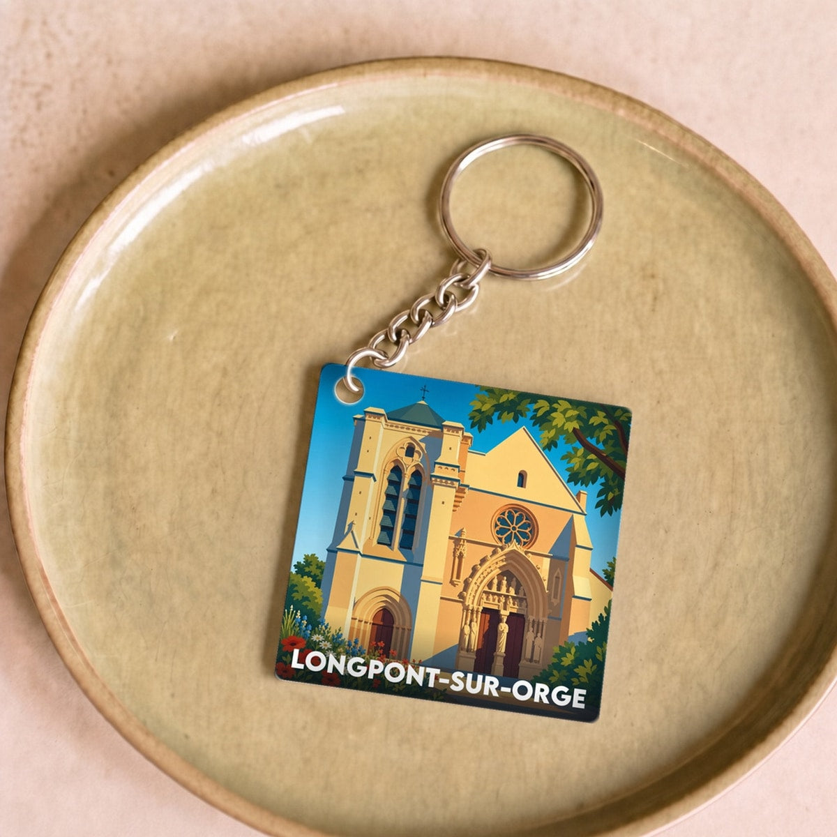 Porte-clés souvenir de la ville de Longpont-sur-Orge avec une illustration stylisée de sa basilique.
