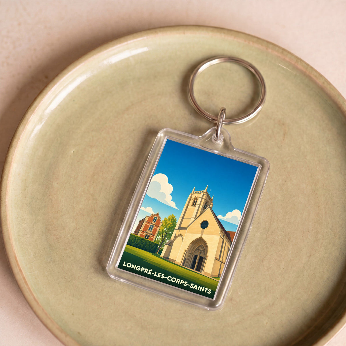 Porte-clés souvenir de la ville de Longpré-les-Corps-Saints avec une illustration stylisée de son église.