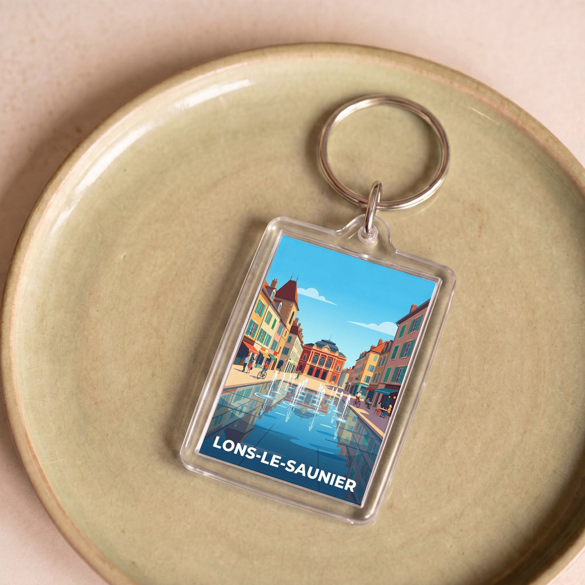 Porte-clés souvenir de la ville de Lons-le-Saunier avec une illustration stylisée.