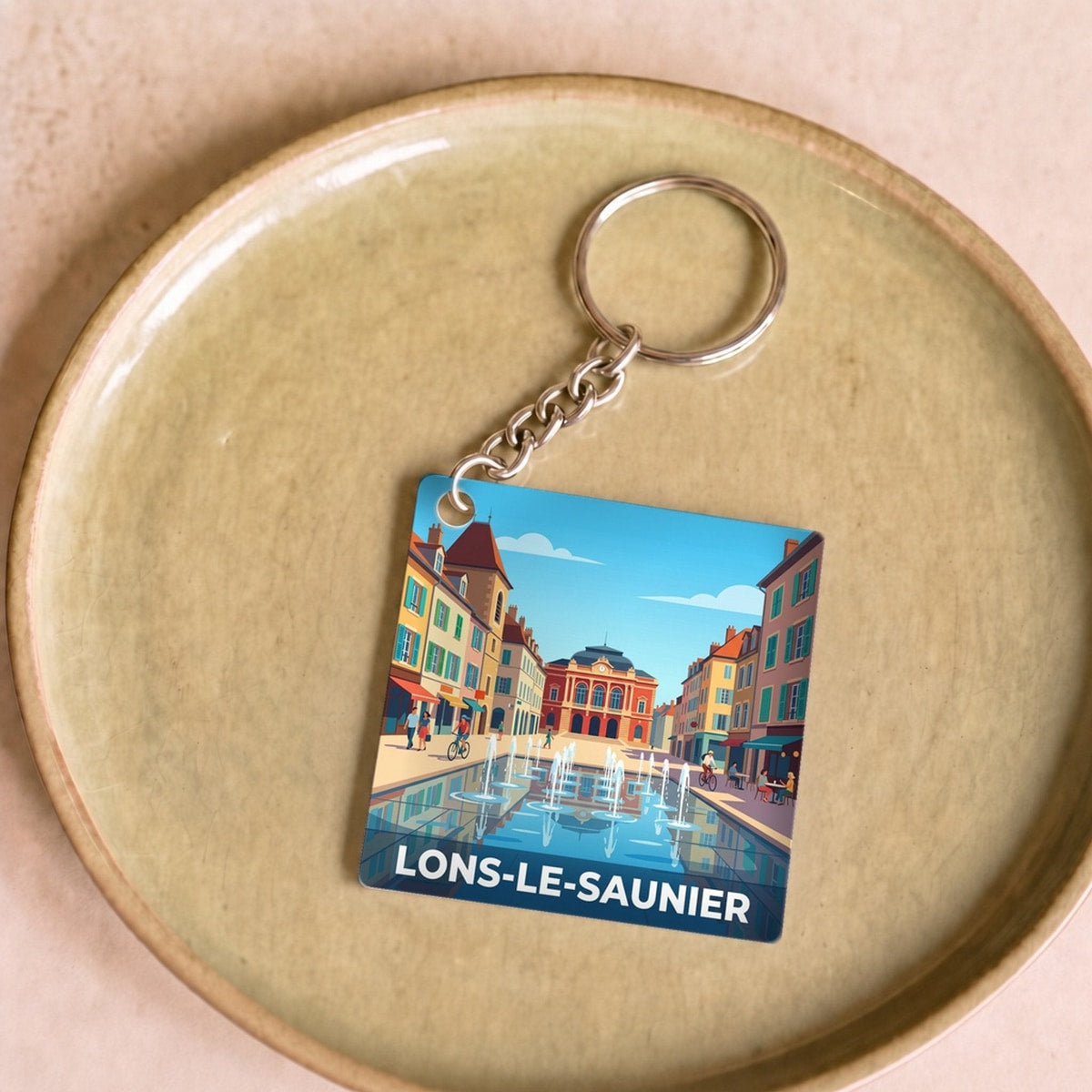 Porte-clés souvenir de la ville de Lons-le-Saunier avec une illustration stylisée.