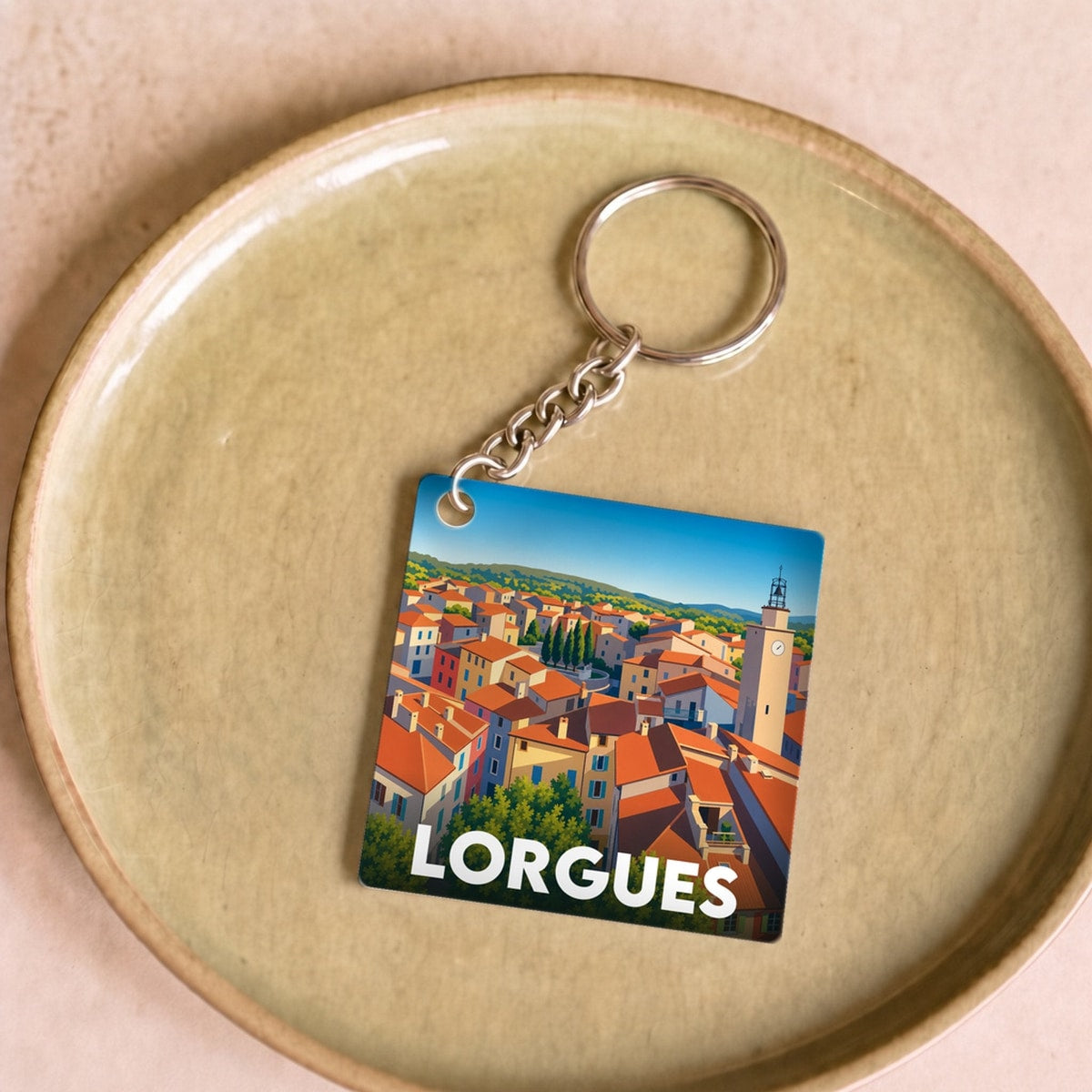 Porte-clés souvenir de la ville de Lorgues avec une illustration stylisée de ses toits provençaux.