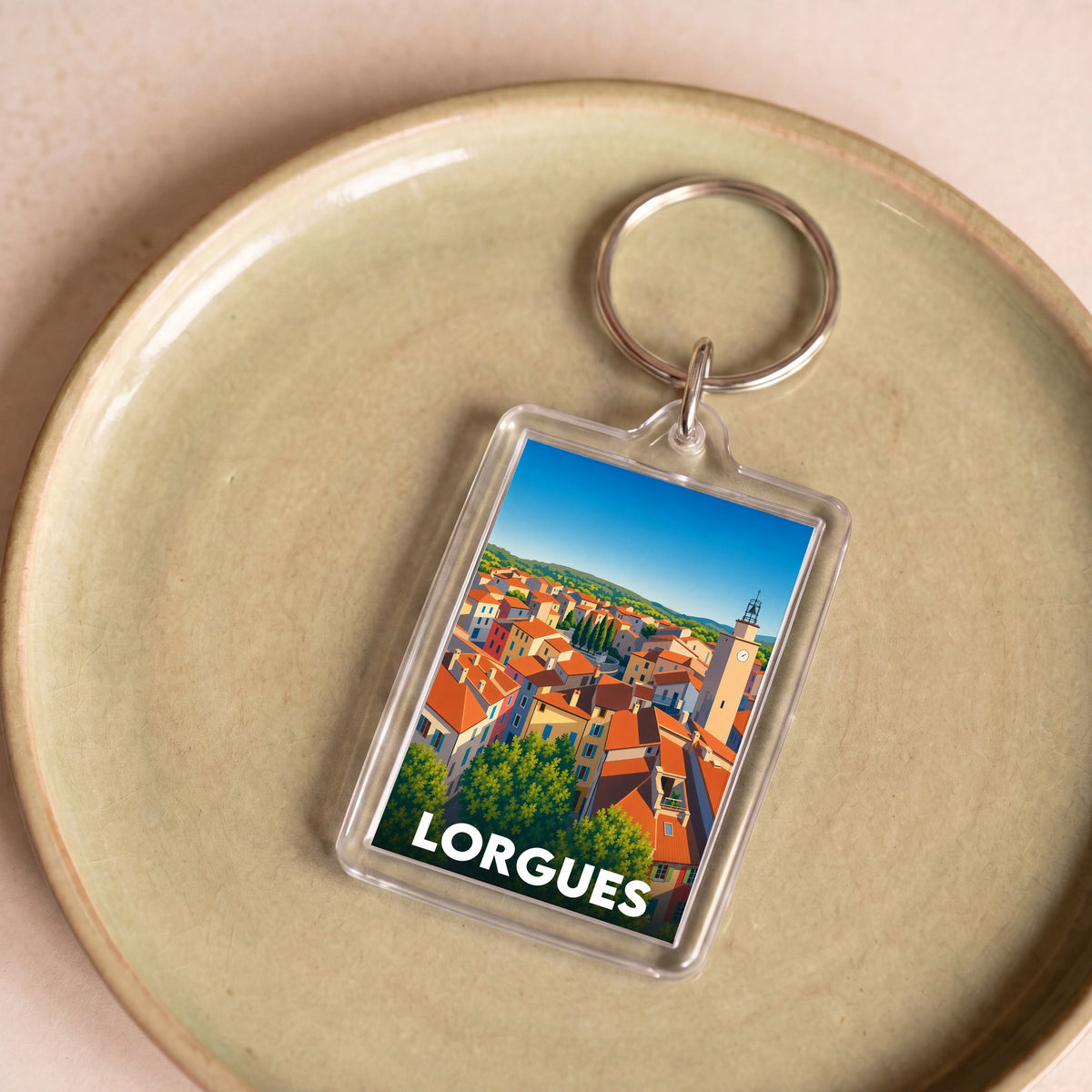Porte-clés souvenir de la ville de Lorgues avec une illustration stylisée de ses toits provençaux.