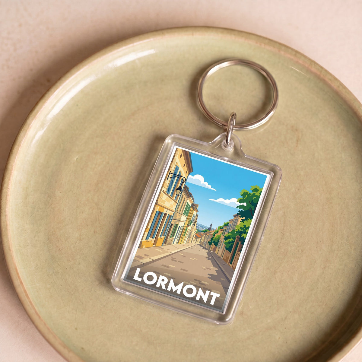 Porte-clés souvenir de la ville de Lormont avec une illustration stylisée d'un paysage urbain.