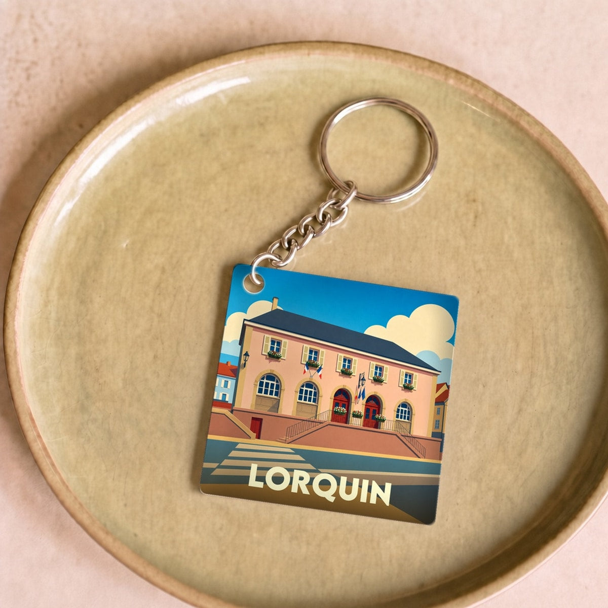 Porte-clés souvenir de la ville de Lorquin avec une illustration stylisée.