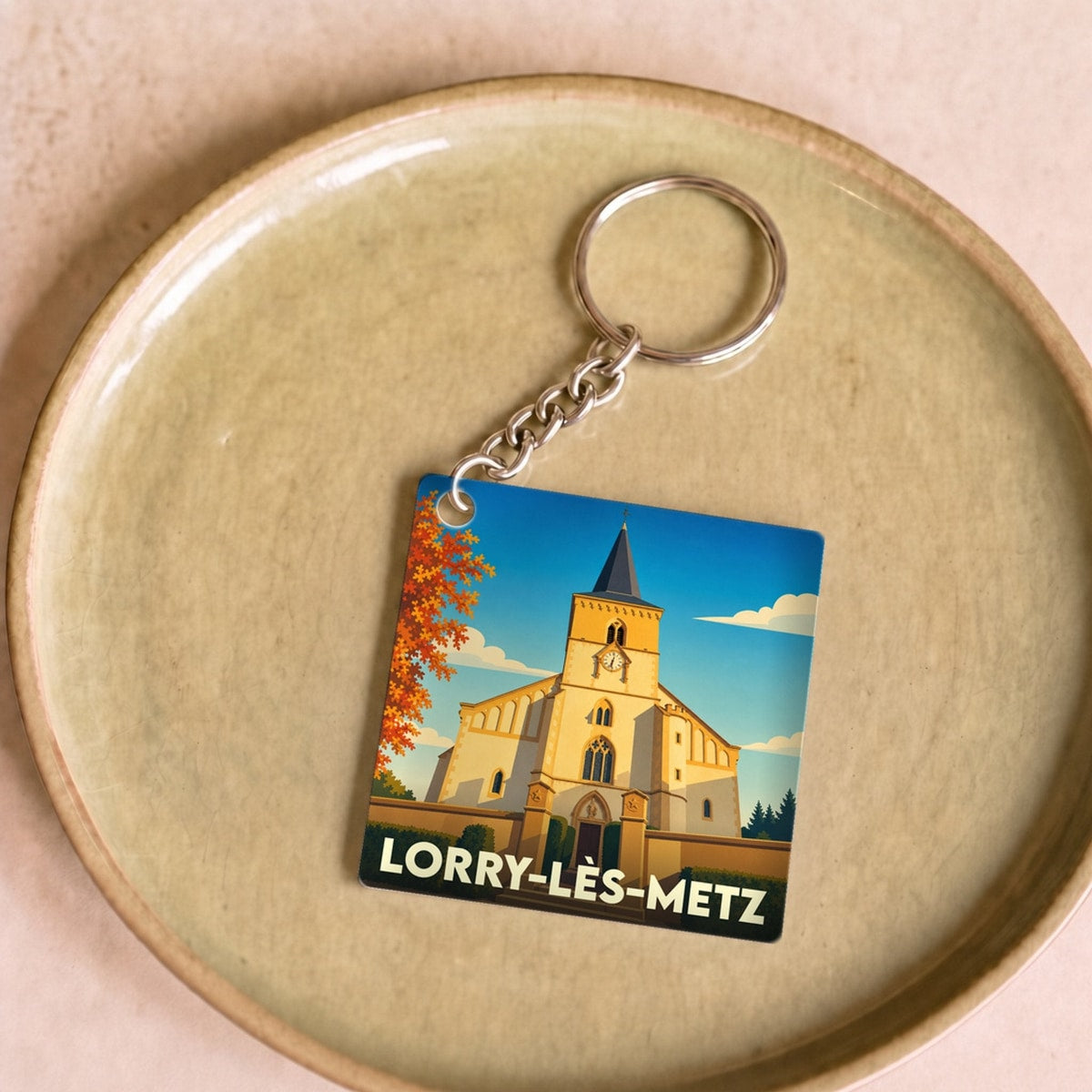 Porte-clés souvenir de la ville de Lorry-lès-Metz avec une illustration stylisée de son église.