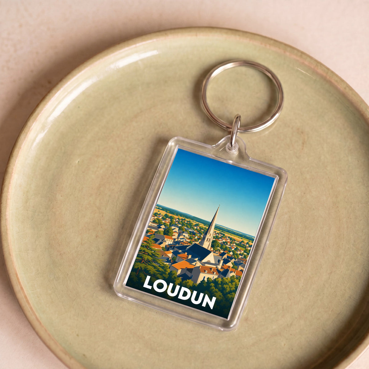 Porte-clés souvenir de la ville de Loudun avec une illustration panoramique stylisée.