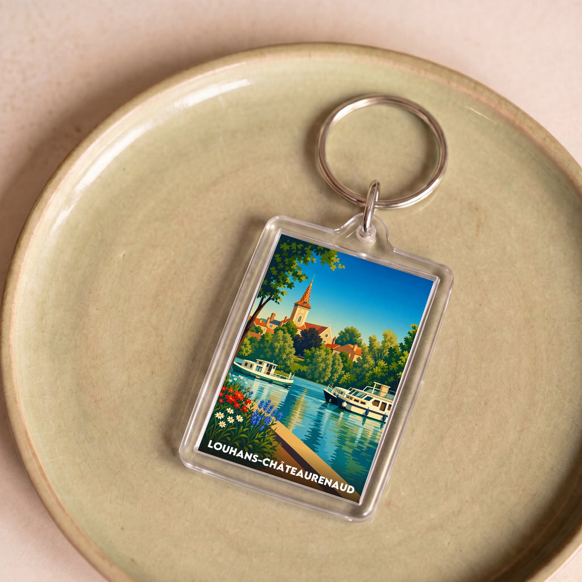 Porte-clés souvenir de la ville de Louhans-Châteaurenaud avec une illustration stylisée.