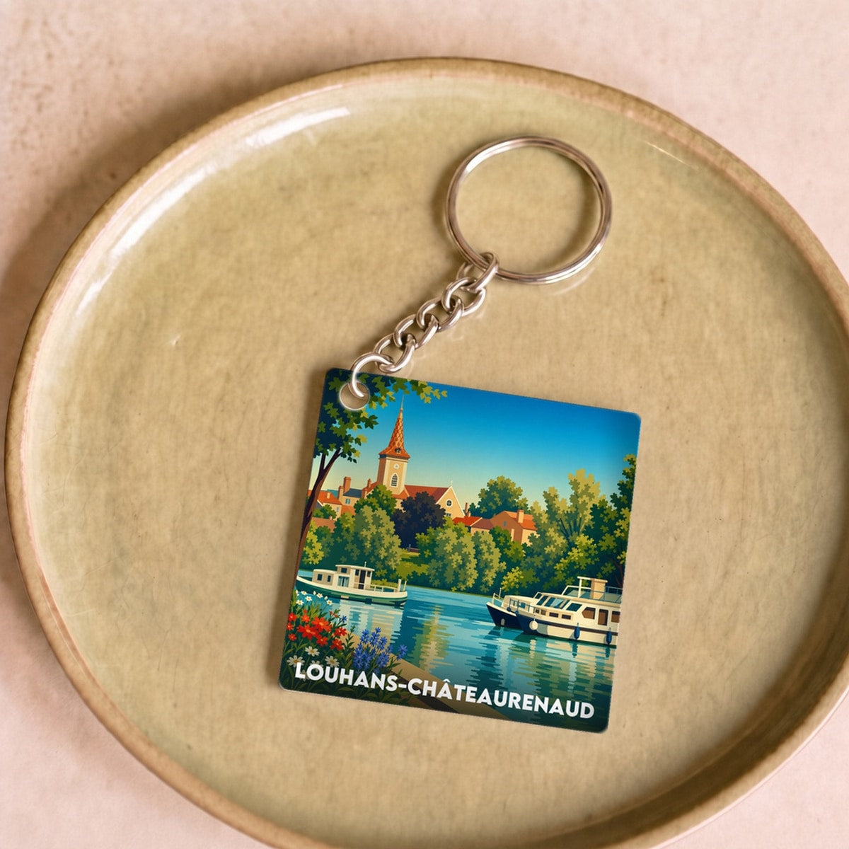 Porte-clés souvenir de la ville de Louhans-Châteaurenaud avec une illustration stylisée.