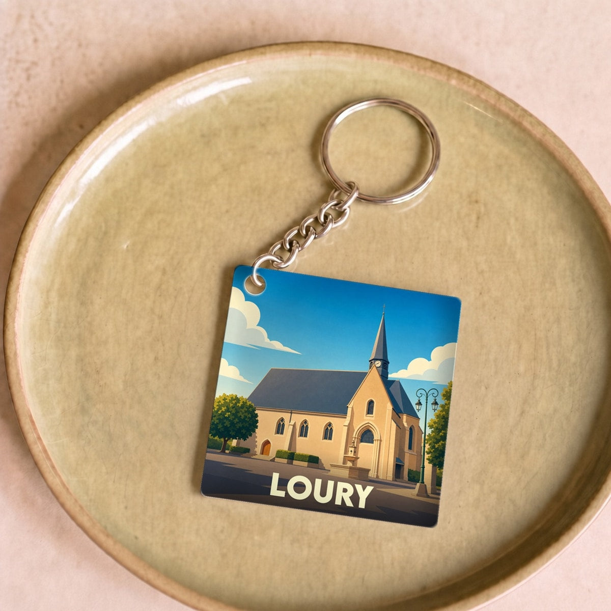 Porte-clés souvenir de la ville de Loury avec une illustration stylisée de son église.