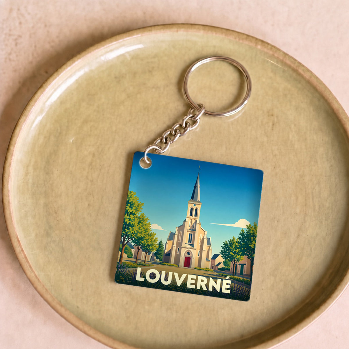 Porte-clés souvenir de la ville de Louverné avec une illustration stylisée de son église.