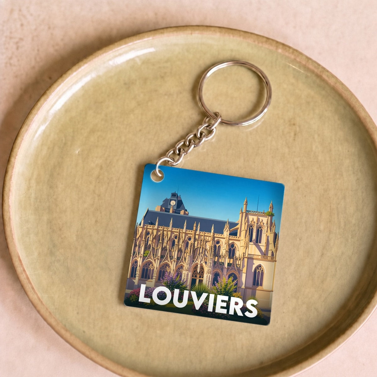 Porte-clés souvenir de la ville de Louviers avec une illustration stylisée.