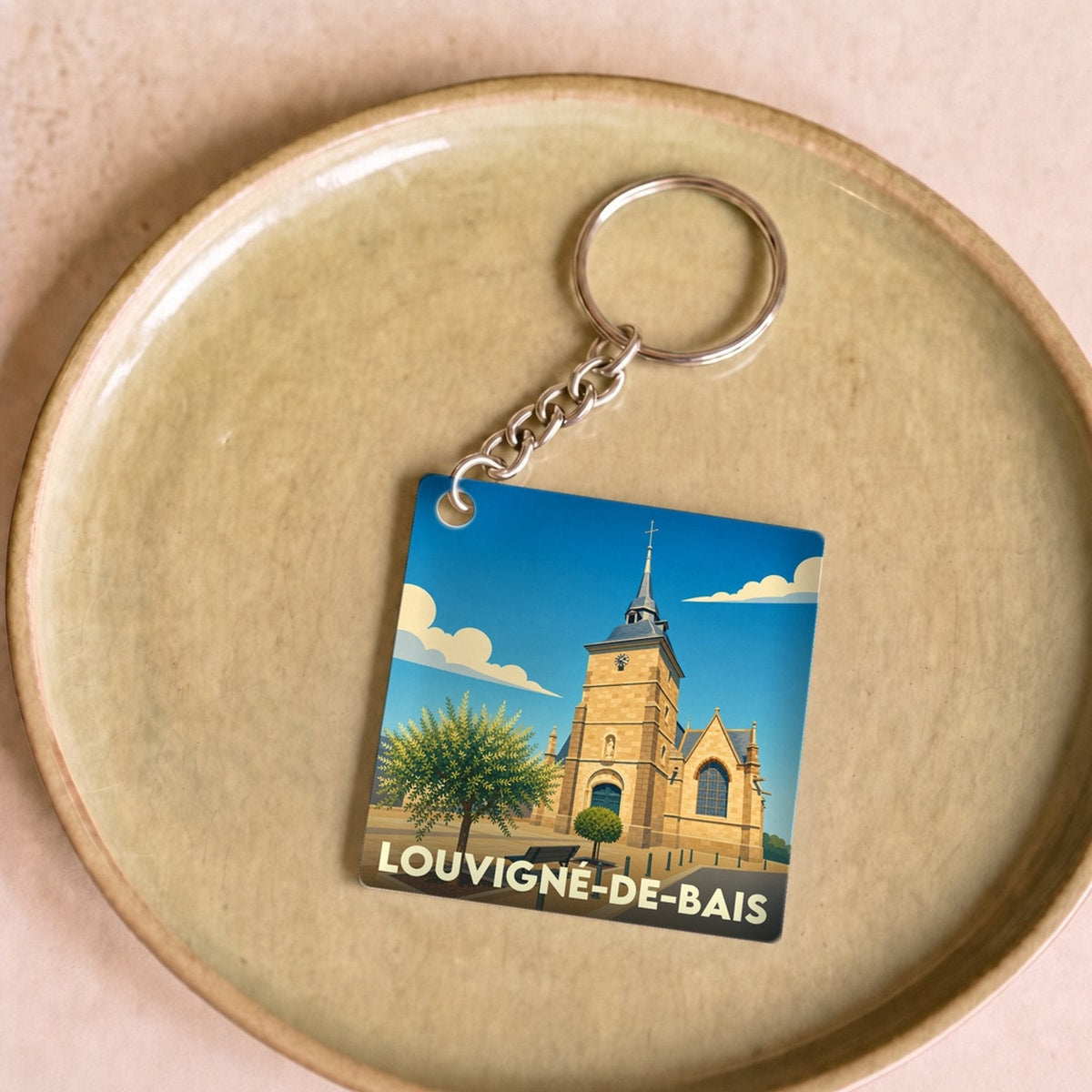 Porte-clés souvenir de la ville de Louvigné-de-Bais avec une illustration stylisée de son église.