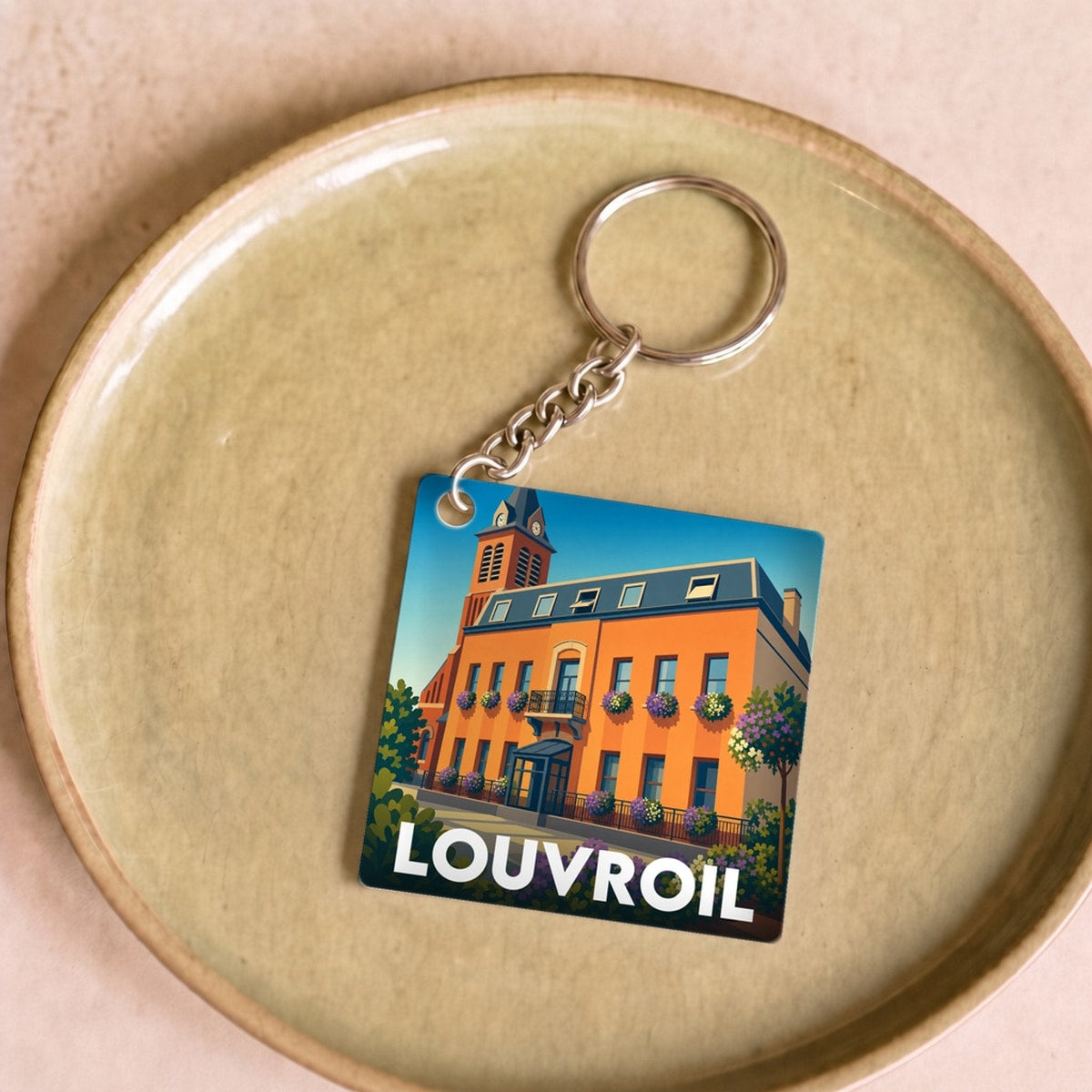 Porte-clés souvenir de la ville de Louvroil avec une illustration stylisée de son hôtel de ville.