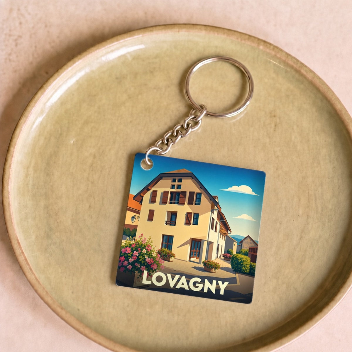 Porte-clés souvenir de la ville de Lovagny avec une illustration stylisée d'un bâtiment typique.