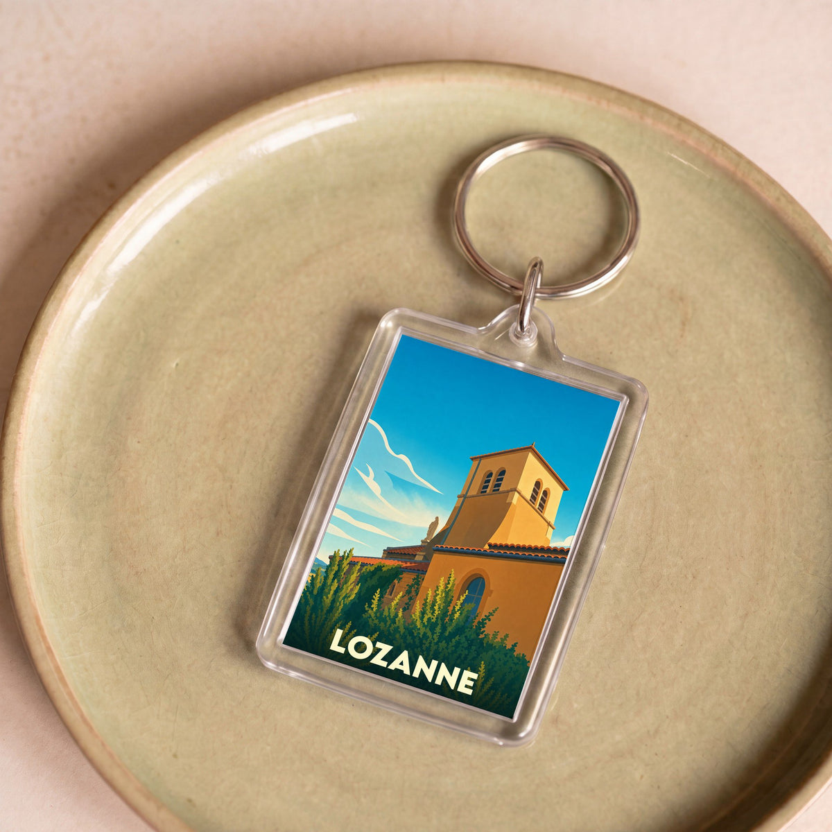Porte-clés souvenir de la ville de Lozanne avec une illustration stylisée.