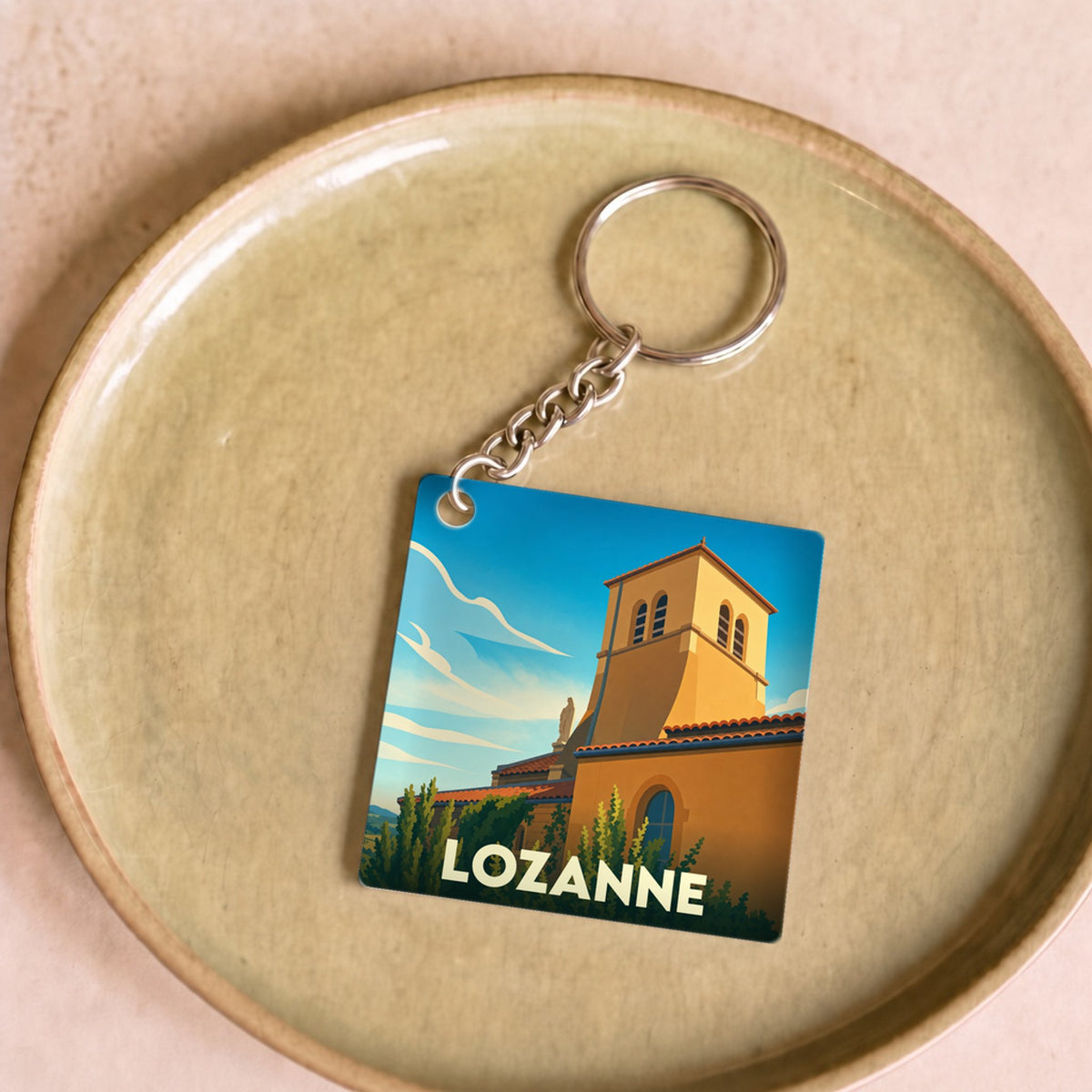 Porte-clés souvenir de la ville de Lozanne avec une illustration stylisée.