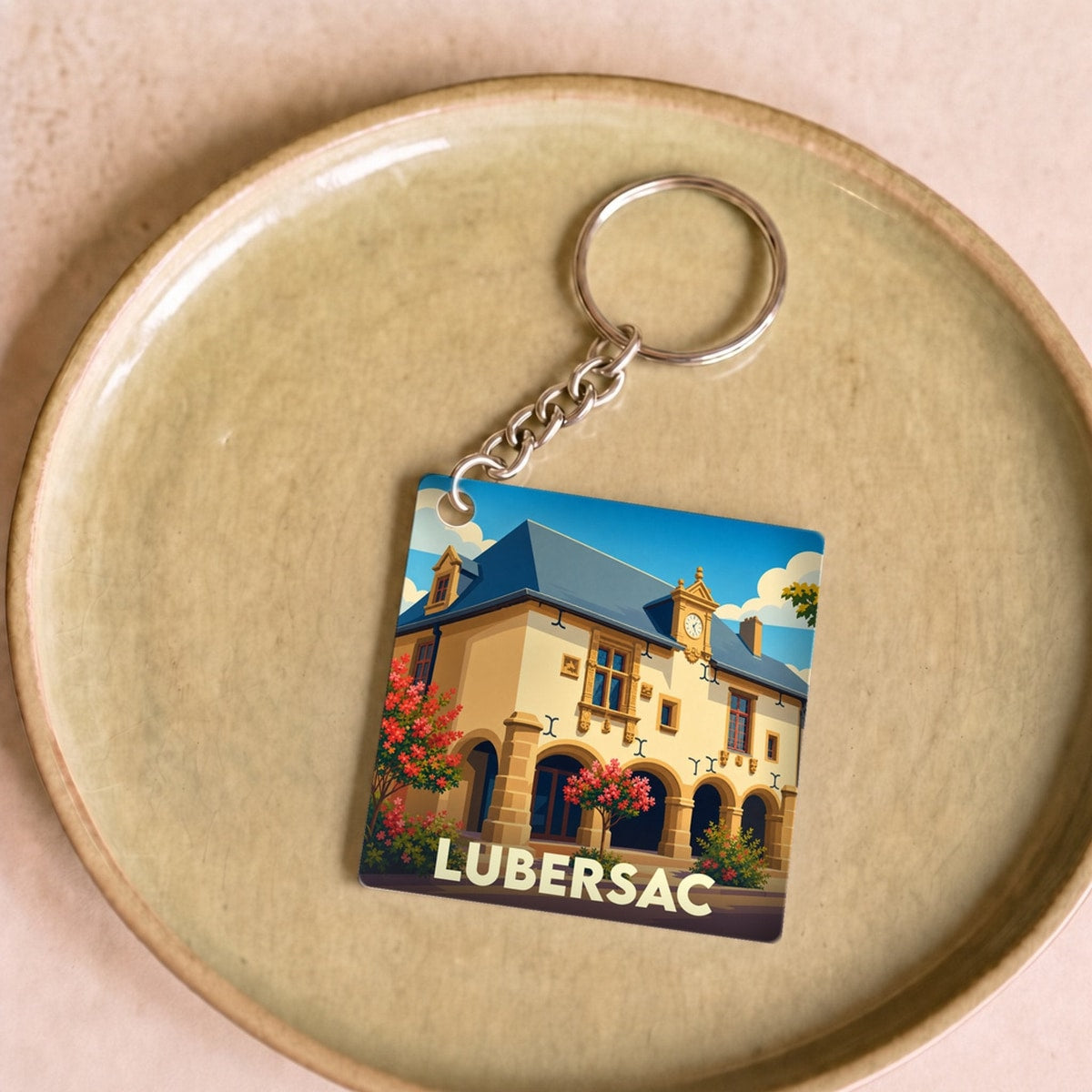 Porte-clés souvenir de la ville de Lubersac avec une illustration stylisée.