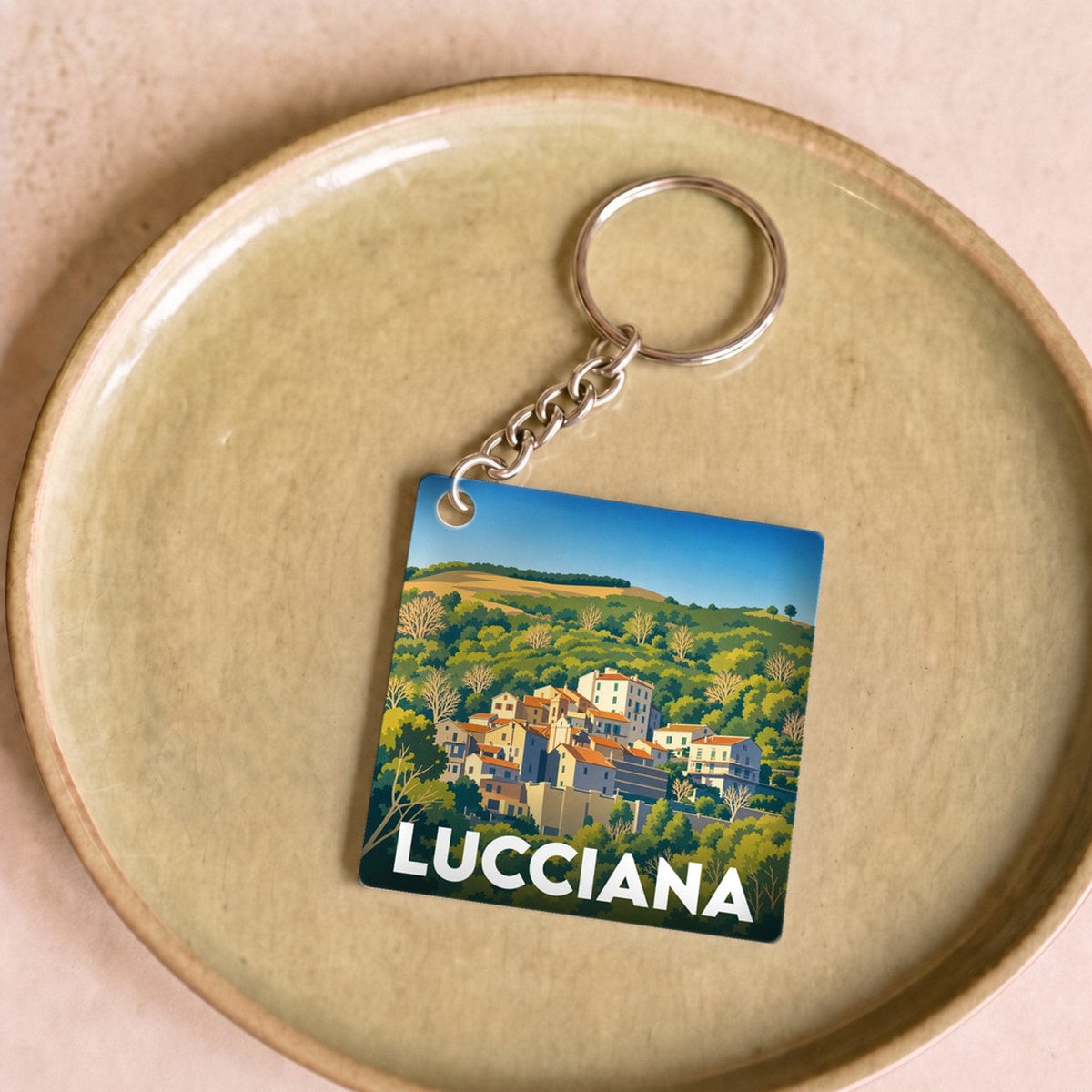 Porte-clés souvenir de la ville de Lucciana avec une illustration stylisée d'un paysage provençal.