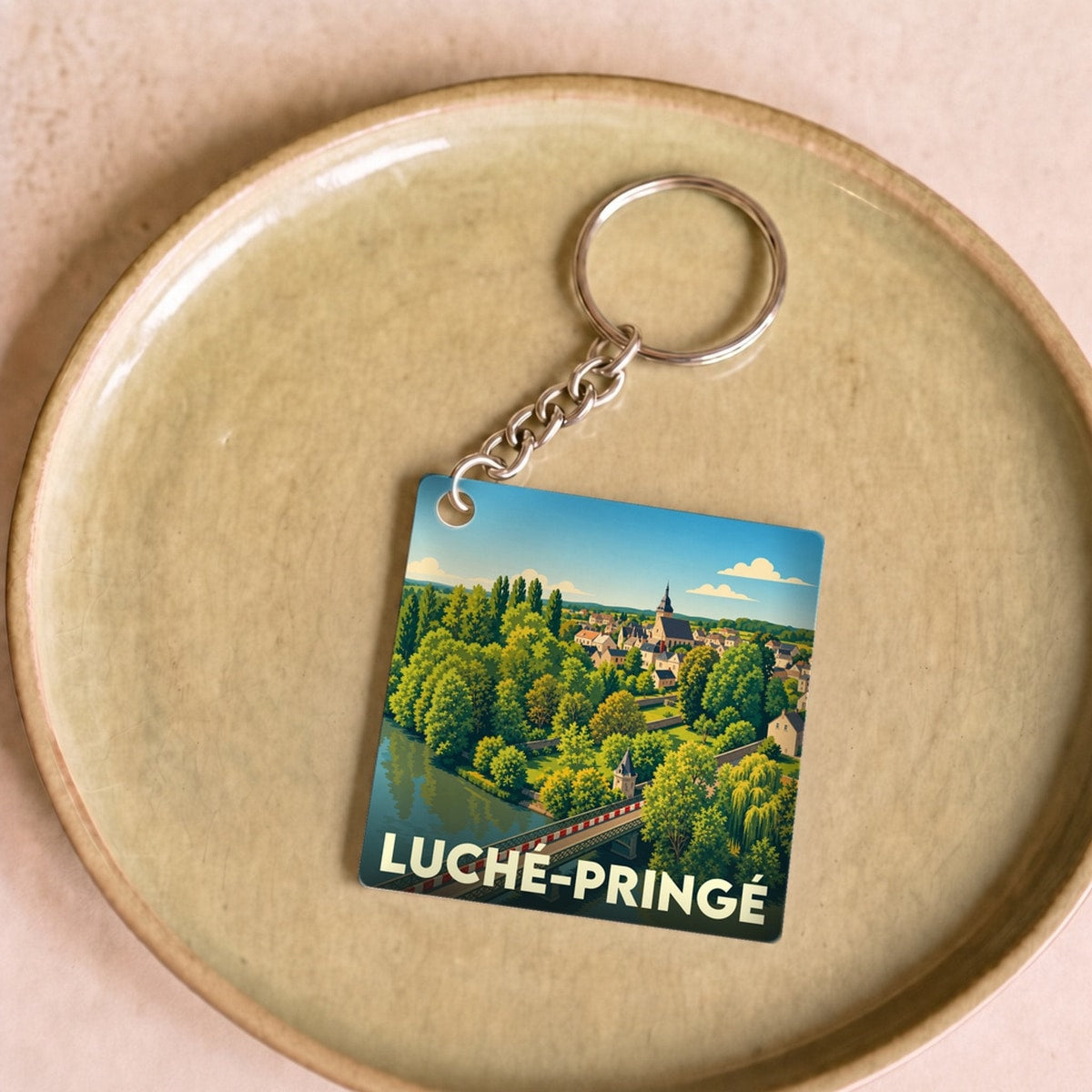 Porte-clés souvenir de la ville de Luché-Pringé avec une illustration stylisée.