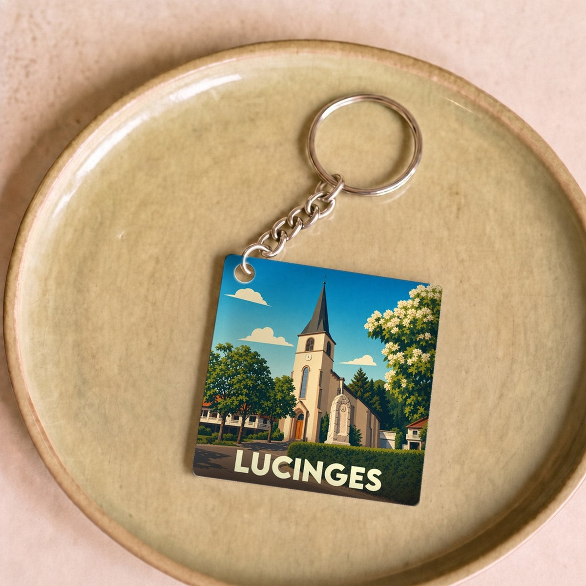 Porte-clés souvenir de la ville de Lucinges avec une illustration stylisée de son église.