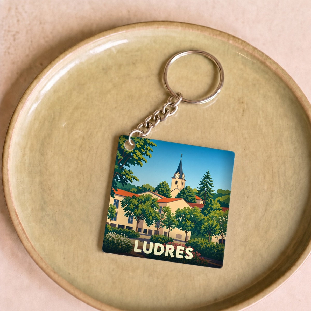 Porte-clés souvenir de la ville de Ludres avec une illustration stylisée.