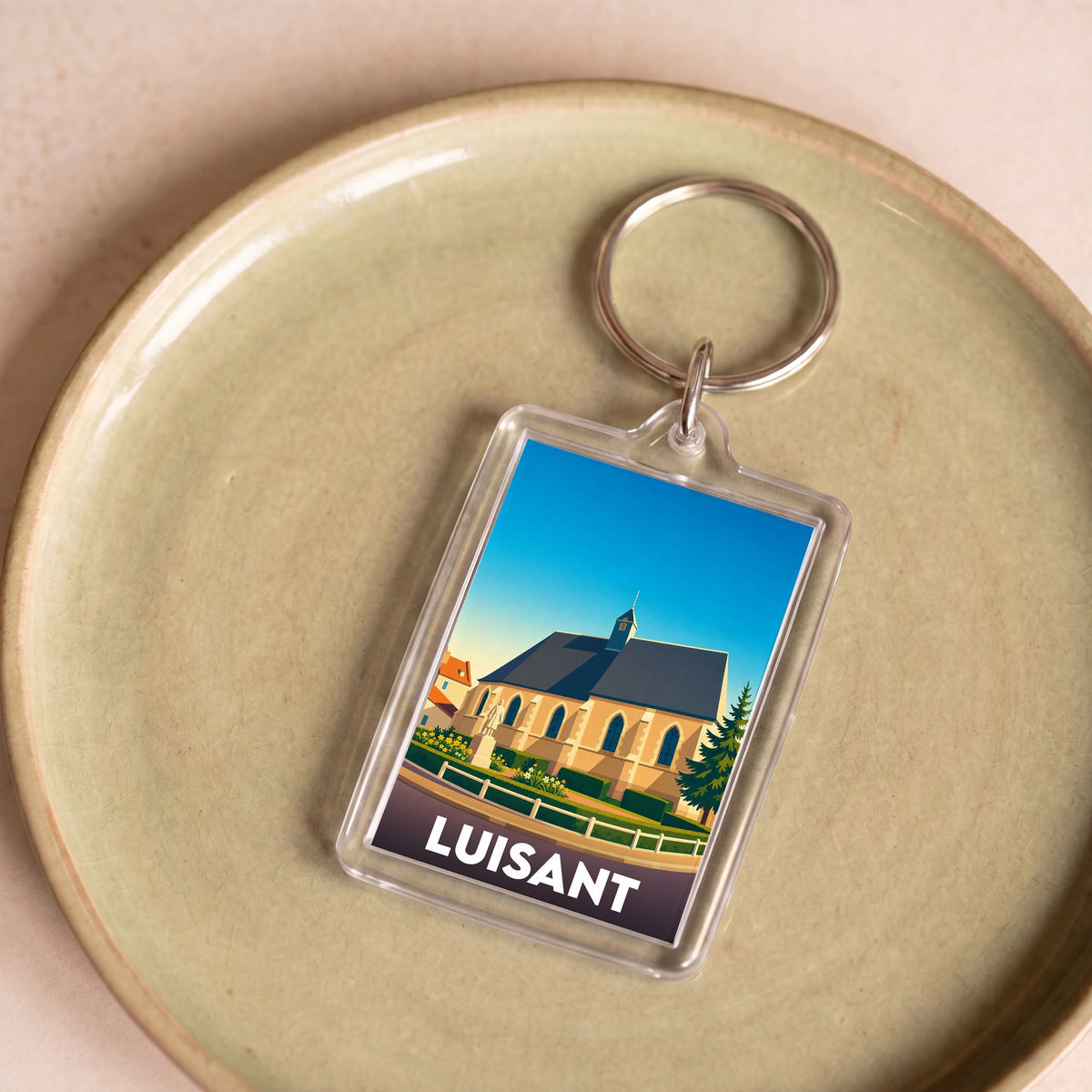 Porte-clés souvenir de la ville de Luisant avec une illustration stylisée de son église.