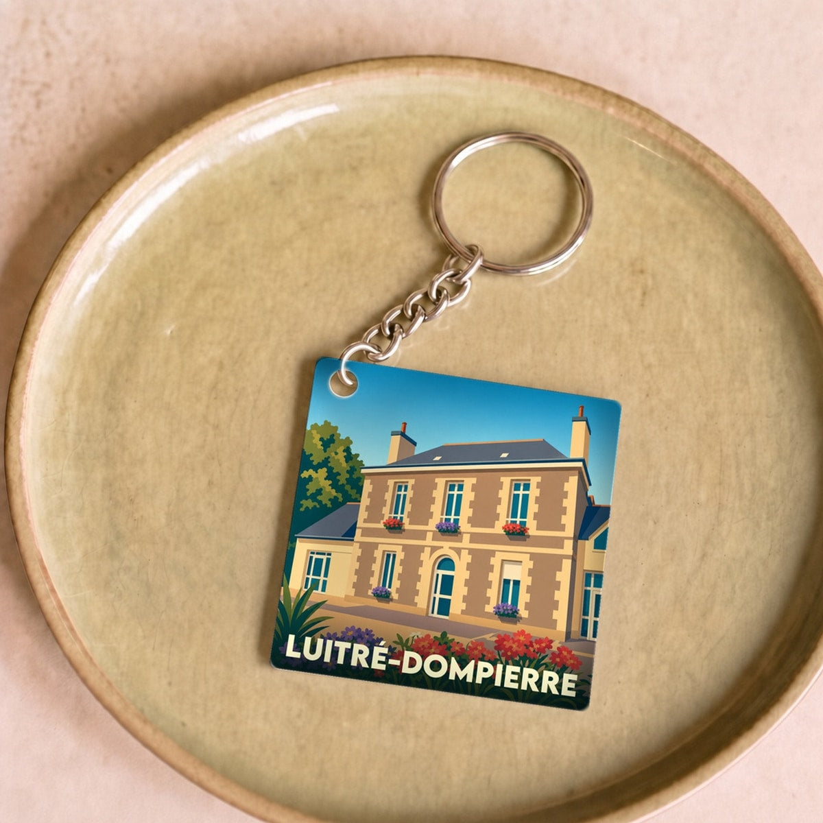 Porte-clés souvenir de la ville de Luitré-Dompierre avec une illustration stylisée.