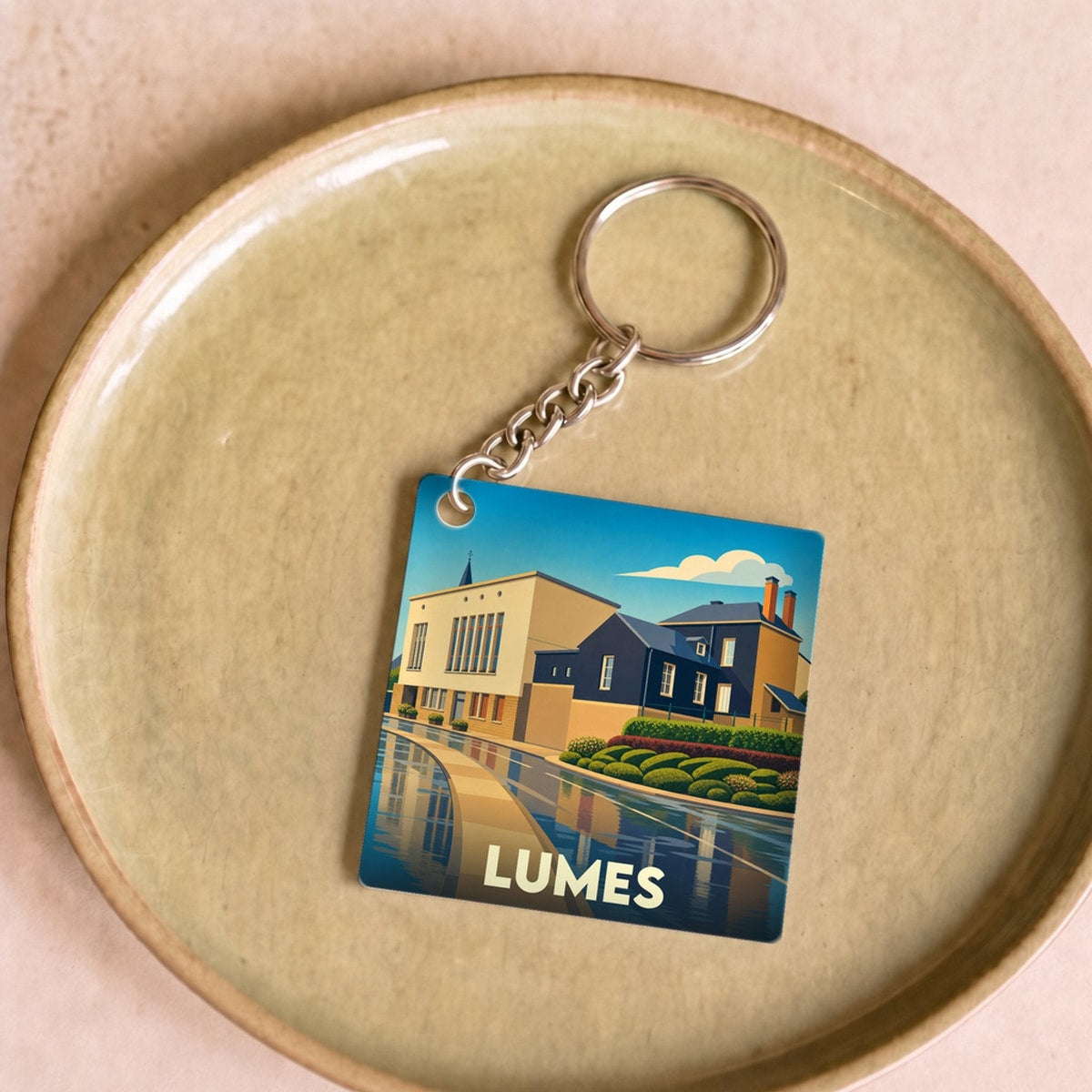 Porte-clés souvenir de la ville de Lumes avec une illustration stylisée.