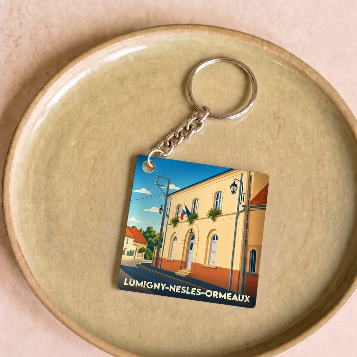 Porte-clés souvenir de la ville de Lumigny-Nesles-Ormeaux avec une illustration stylisée.