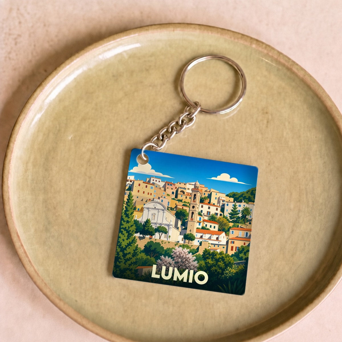 Porte-clés souvenir de la ville de Lumio avec une illustration stylisée et colorée.