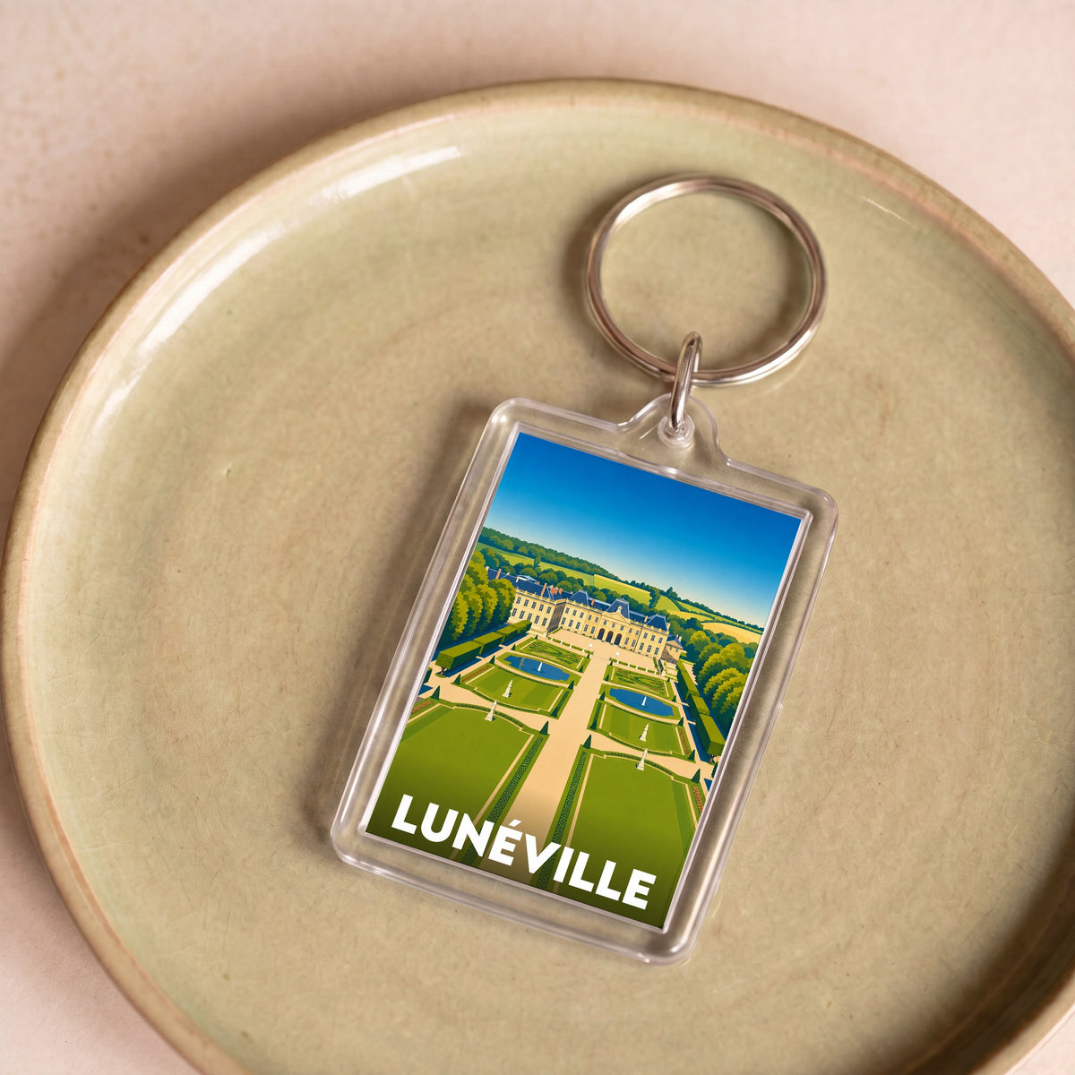 Porte-clés souvenir de la ville de Lunéville avec une illustration stylisée.