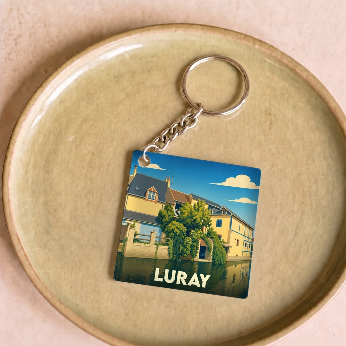 Porte-clés souvenir de la ville de Luray avec une illustration stylisée d'une maison au bord de l'eau.