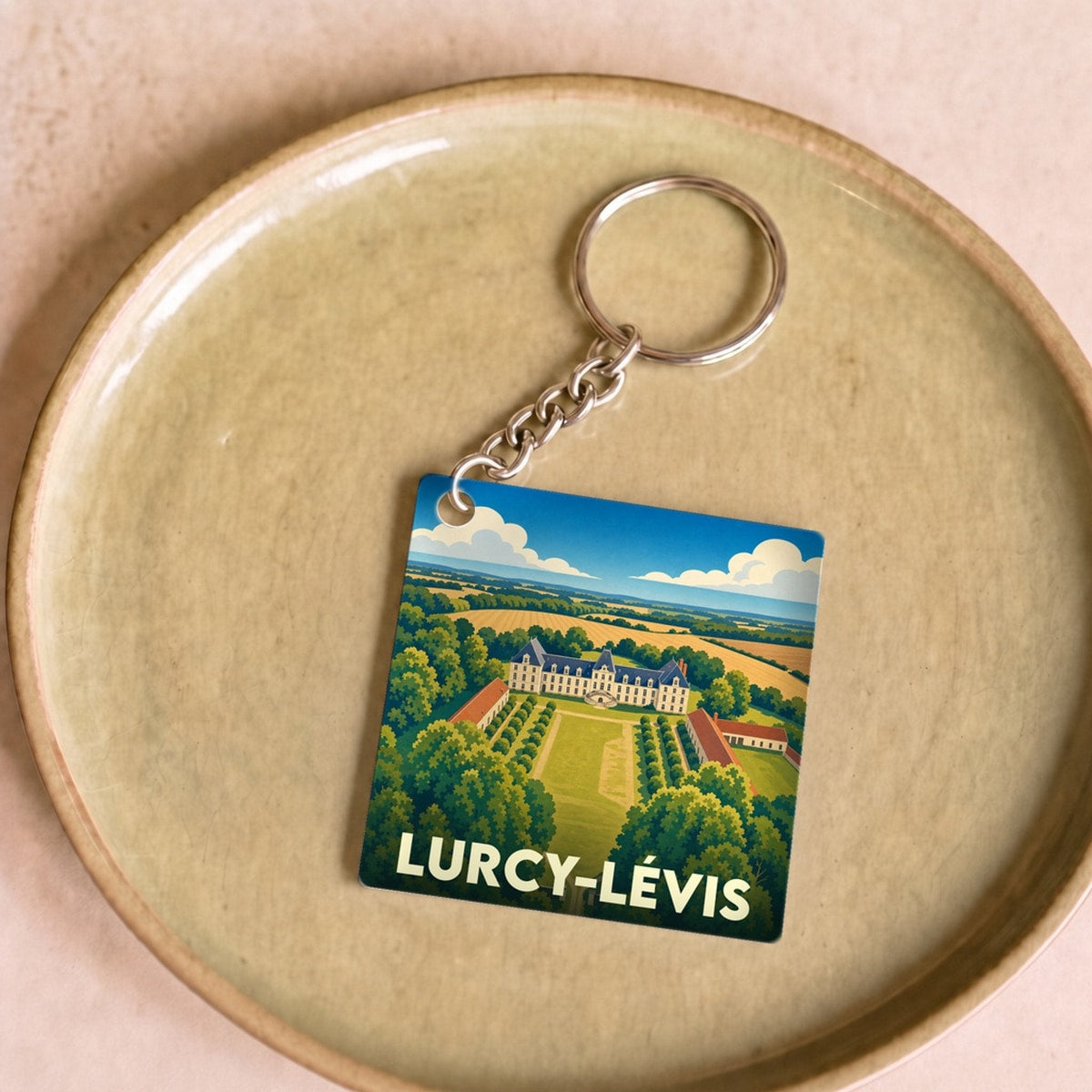 Porte-clés souvenir de la ville de Lurcy-Lévis avec une illustration stylisée de son château.