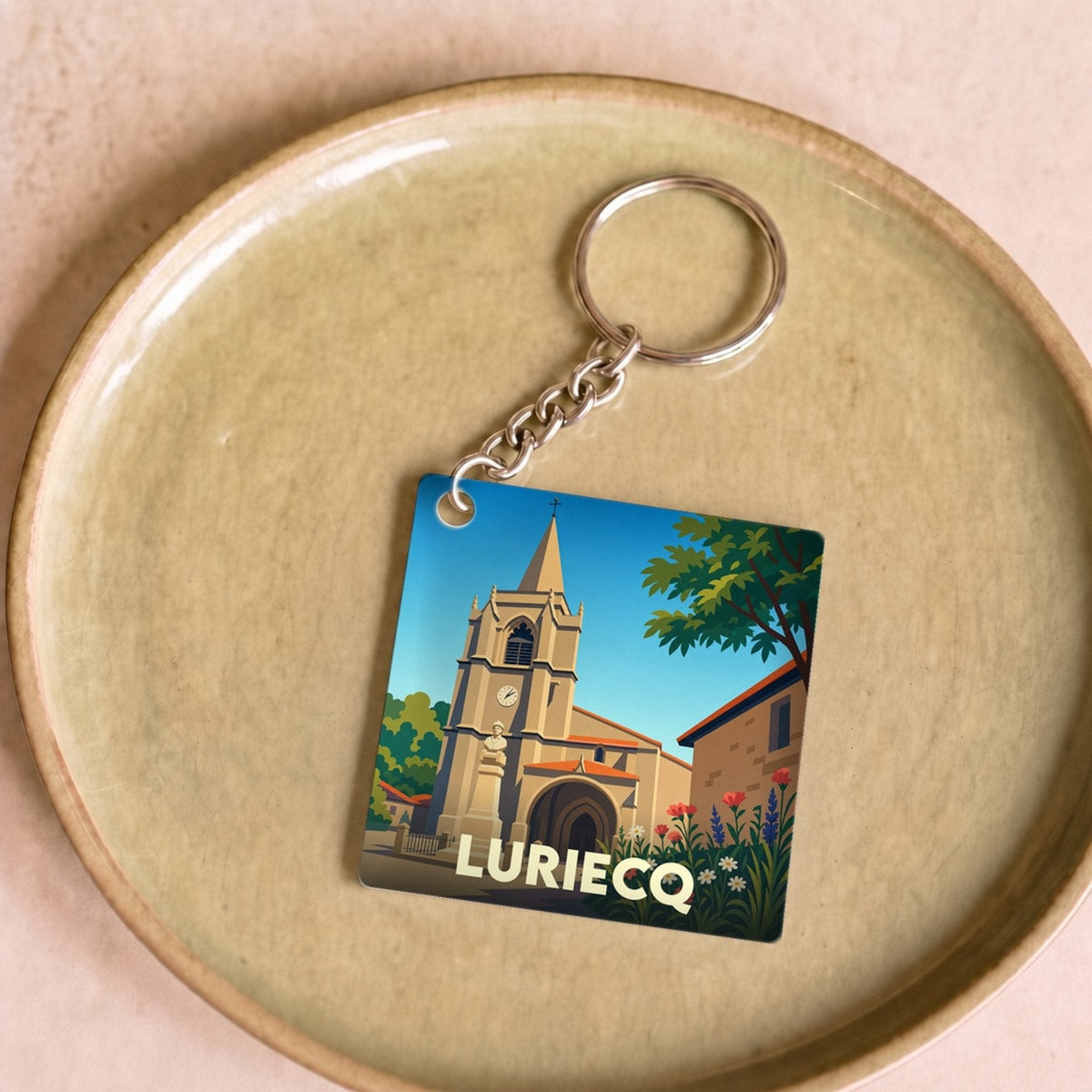 Porte-clés souvenir de la ville de Luriecq avec une illustration stylisée de son église.