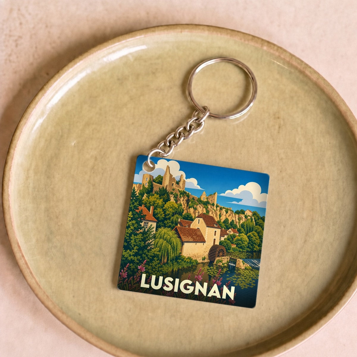 Porte-clés souvenir de la ville de Lusignan avec une illustration stylisée de son paysage historique.