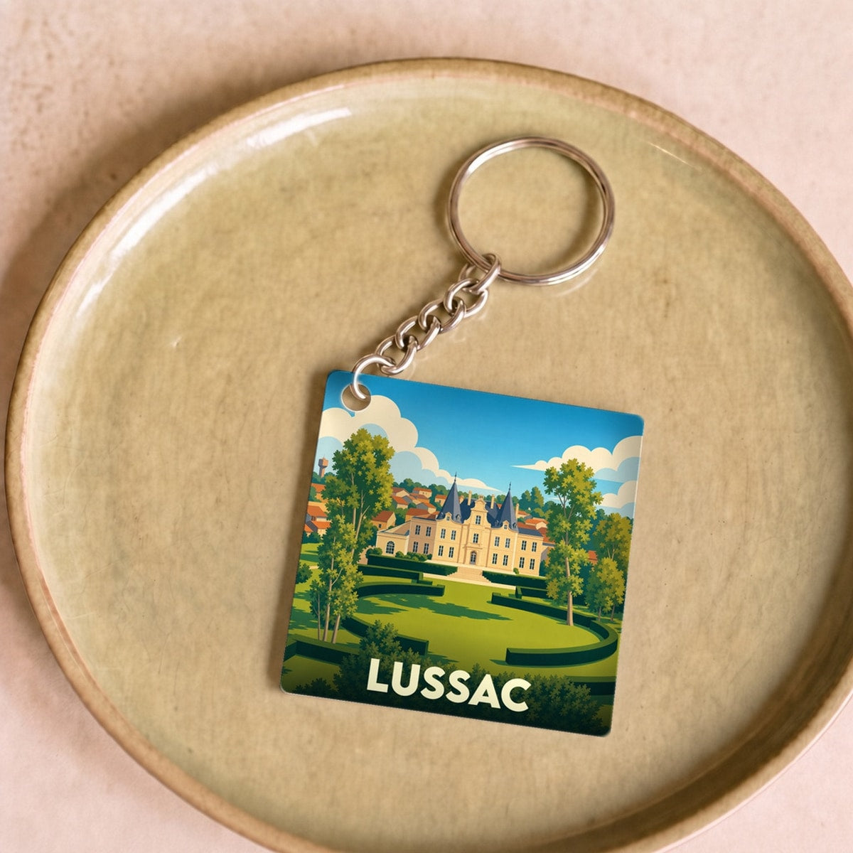 Porte-clés souvenir de la ville de Lussac avec une illustration stylisée.