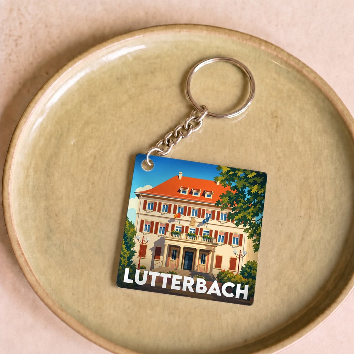 Porte-clés souvenir de la ville de Lutterbach avec une illustration stylisée de son architecture.
