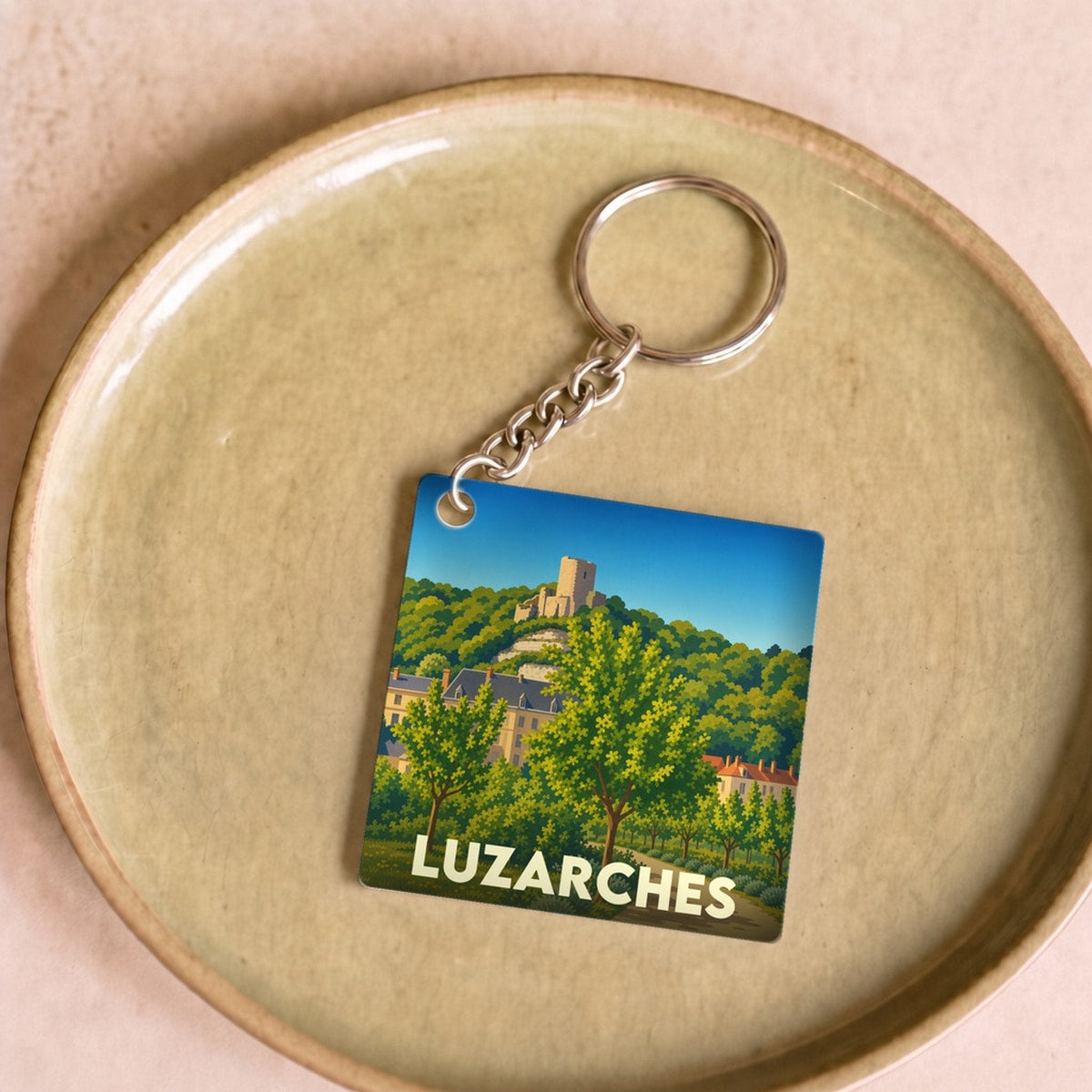 Porte-clés souvenir de la ville de Luzarches avec une illustration stylisée de son patrimoine et de ses paysages.