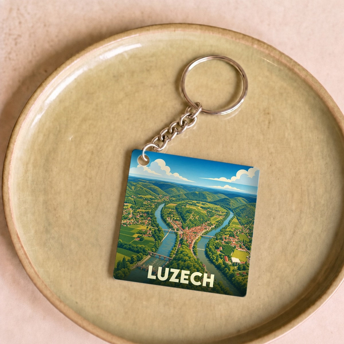Porte-clés souvenir de la ville de Luzech avec une illustration stylisée d'un méandre du Lot.