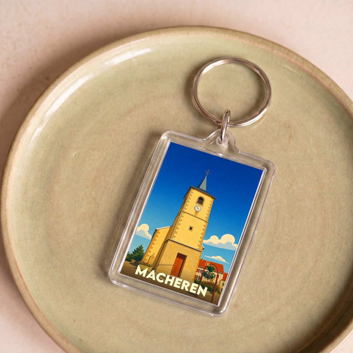 Porte-clés souvenir de la ville de Macheren avec une illustration stylisée de son église.