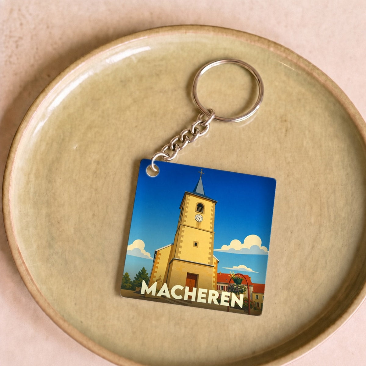 Porte-clés souvenir de la ville de Macheren avec une illustration stylisée de son église.