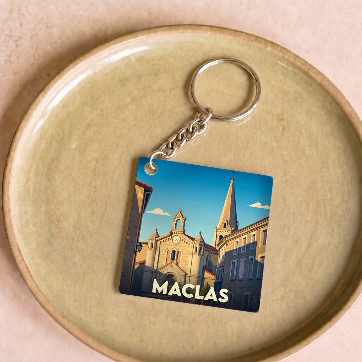 Porte-clés souvenir de la ville de Maclas avec une illustration stylisée de son église.