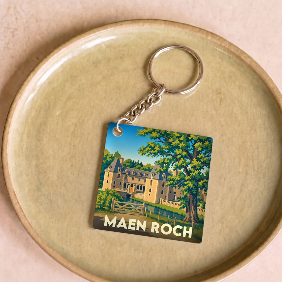Porte-clés souvenir de la ville de Maen Roch avec une illustration stylisée d'un château.