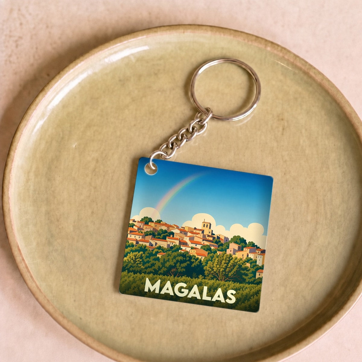 Porte-clés souvenir de la ville de Magalas avec une illustration stylisée et colorée.
