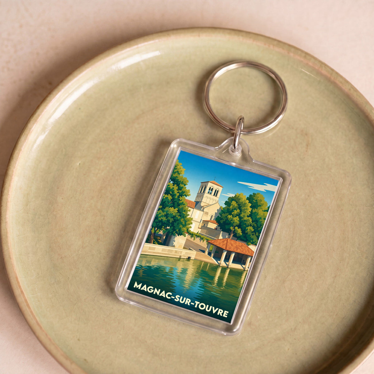 Porte-clés souvenir de la ville de Magnac-sur-Touvre avec une illustration stylisée.