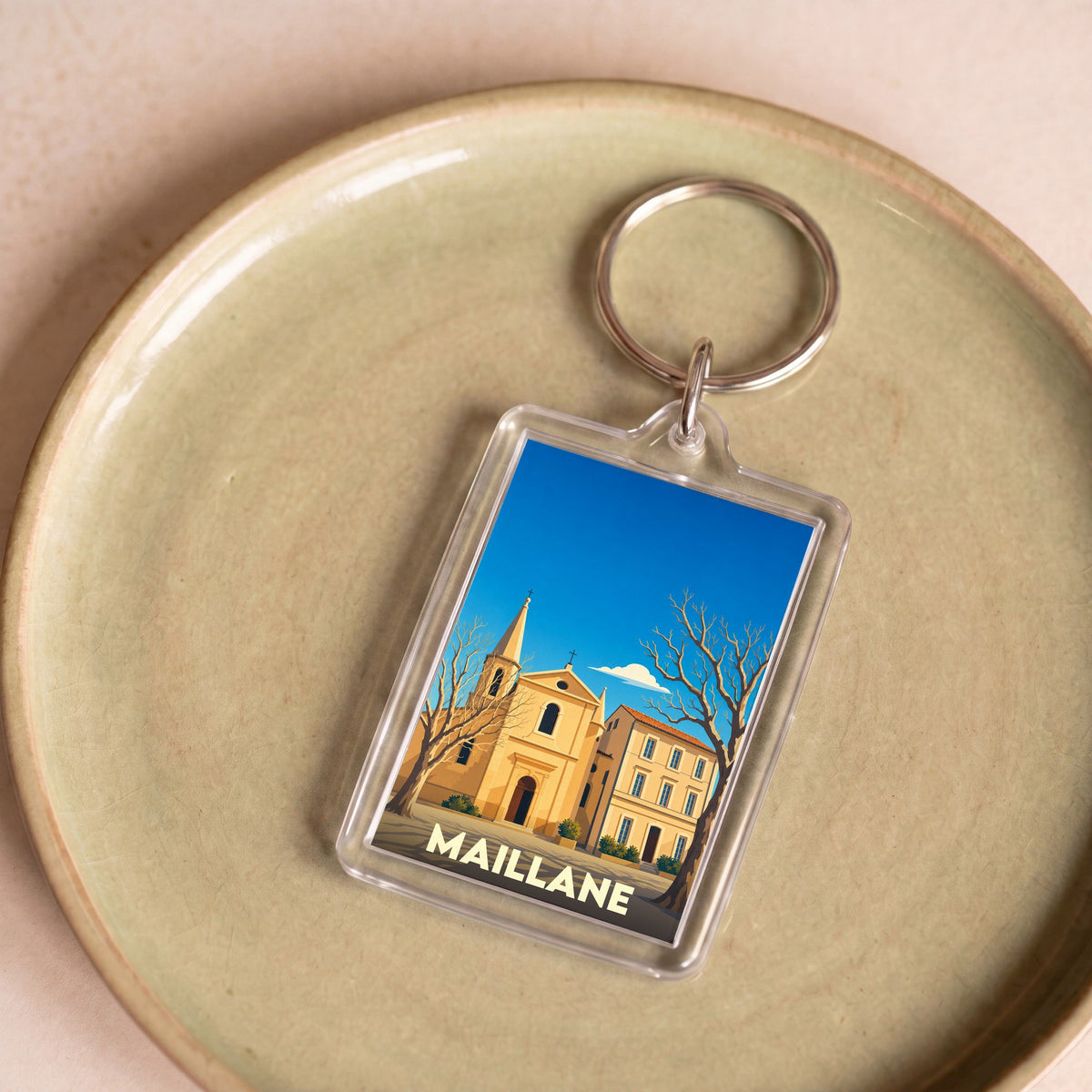 Porte-clés souvenir de la ville de Maillane avec une illustration stylisée.