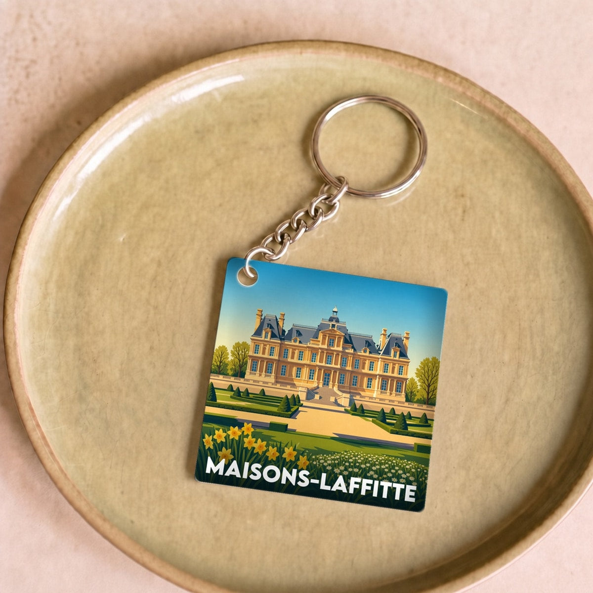 Porte-clés souvenir de la ville de Maisons-Laffitte avec une illustration stylisée.
