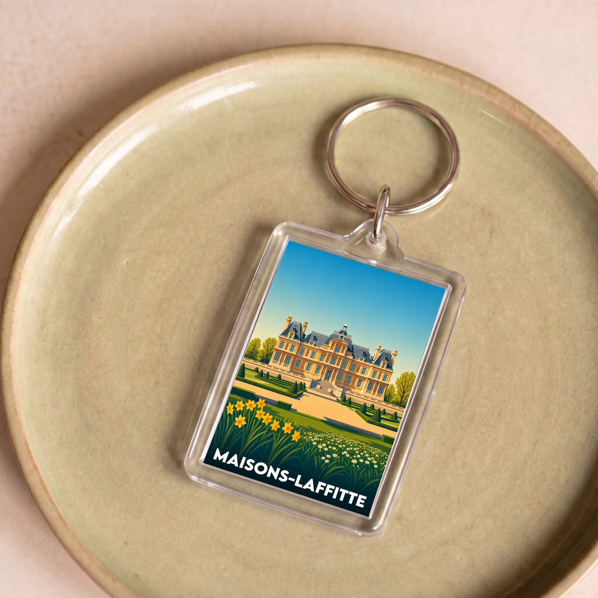 Porte-clés souvenir de la ville de Maisons-Laffitte avec une illustration stylisée.