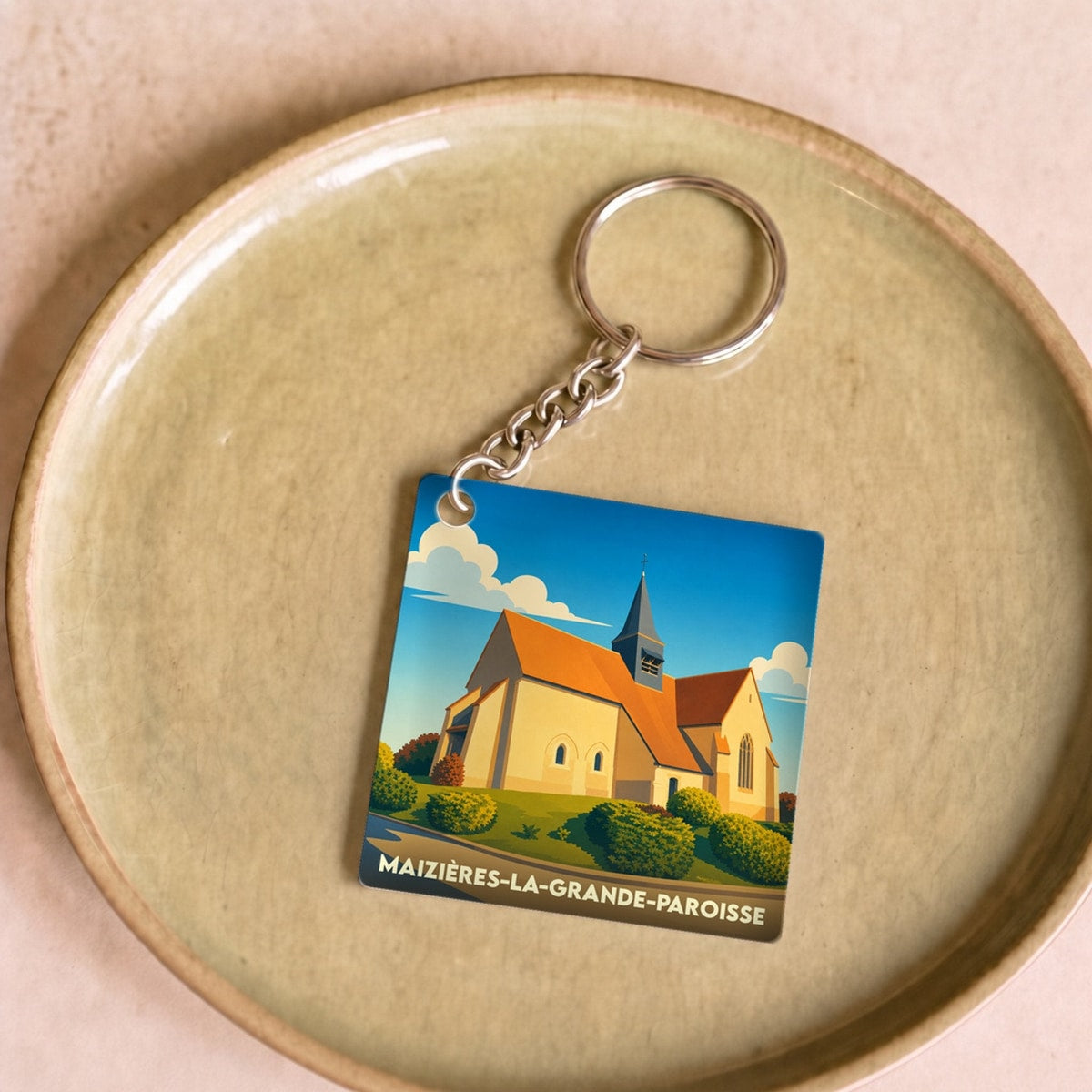 Porte-clés souvenir de la ville de Maizières-la-Grande-Paroisse avec une illustration stylisée de son église.