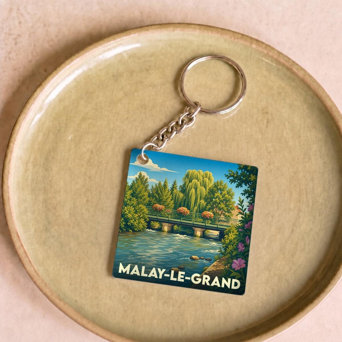 Porte-clés souvenir de la ville de Malay-le-Grand avec une illustration stylisée d'un pont fleuri.